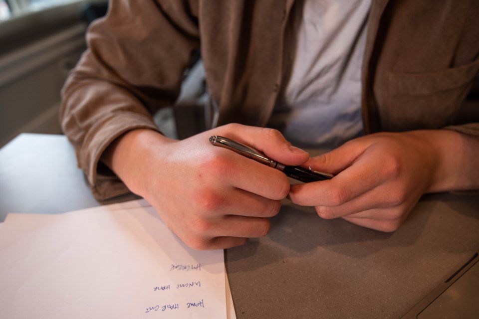 Main tenant un stylo au-dessus d'un document sur un bureau